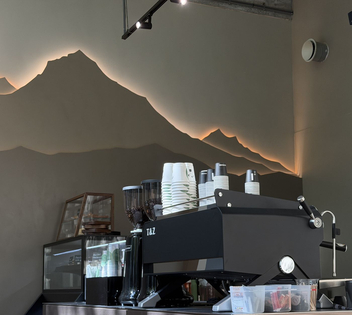 De bar met espressomachine voor de verlichte bergwand