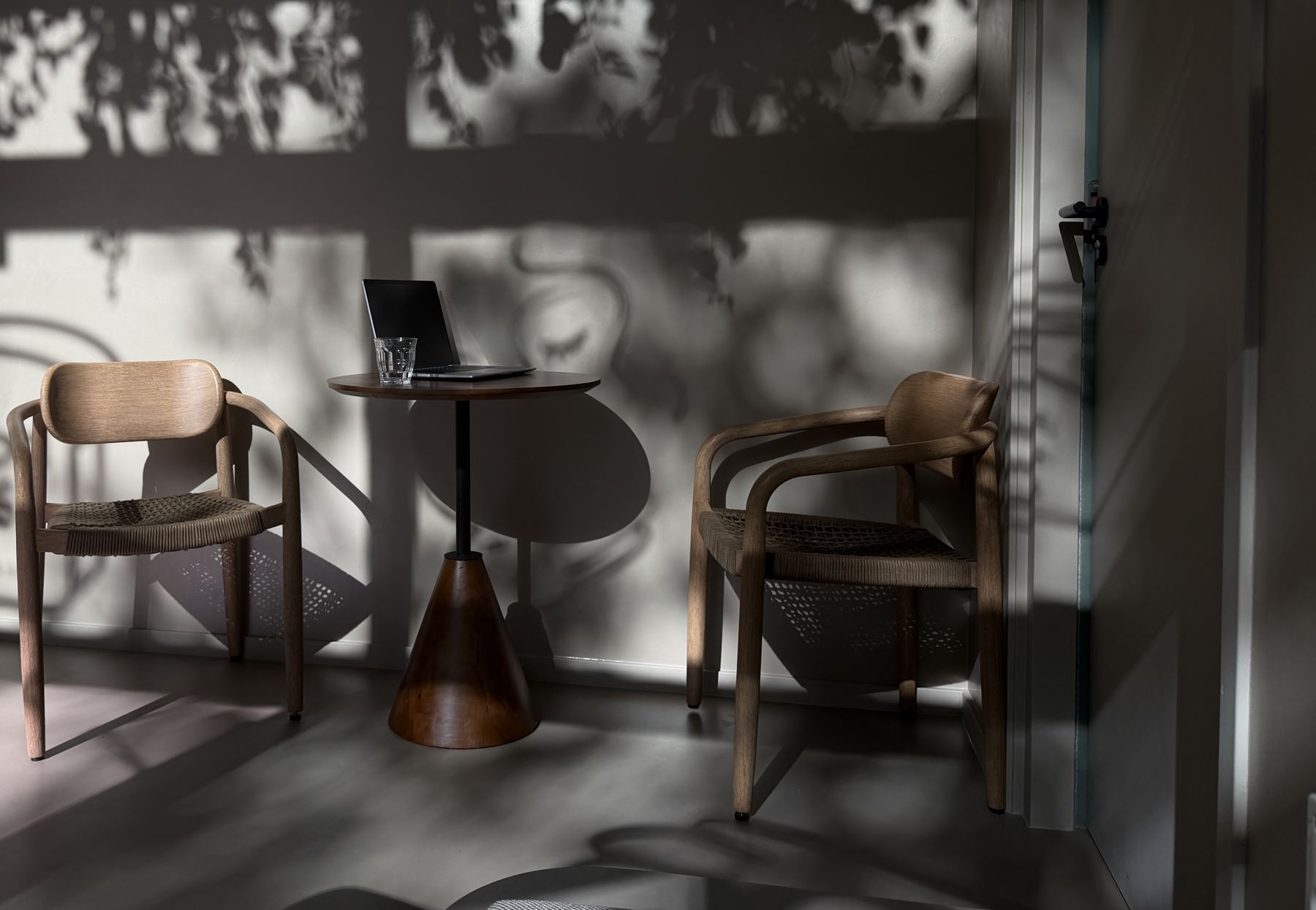 Houten stoelen en een walnoten tafeltje in de middagzon
